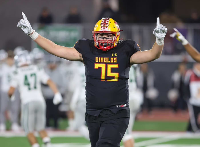 Mission Viejo 6-foot-6, 290-pound tackle Mark Schroller signaling his team's state Division 1-AA championship.